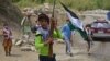 Des enfants portant des fusils de chasse et un drapeau traversent une route dans la région de Bandejoy du district de Dara, dans la province du Panjshir, le 21 août 2021, quelques jours après la prise de contrôle de l'Afghanistan