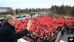 Presiden Turki Recep Tayyip Erdogan melambaikan tangan ke sekelompok pekerja di bandara di Ankara, Turki, 7 Desember 2017 sebelum keberangkatannya dalam lawatan resmi dua hari ke Yunani.