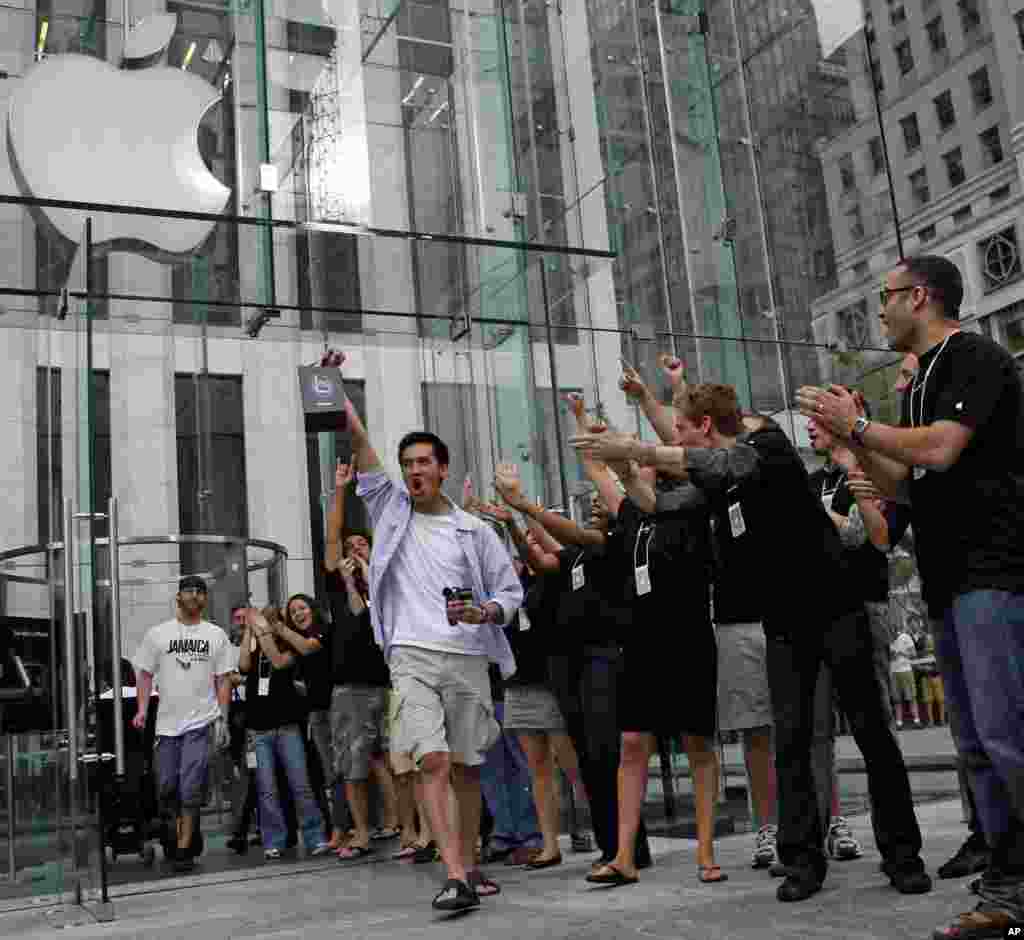 Apple employees cheers as an excited customer leaves the Apple Store with his new iPhone Friday, June 29, 2007 in New York.