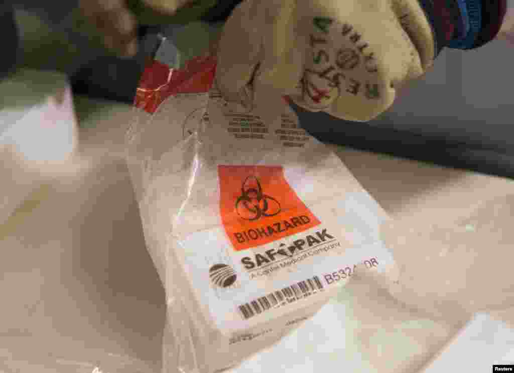 A medical staff holds a package of an experimental candidate vaccine rVSV-ZEBOV against Ebola virus disease at the University Hospital in Geneva, Switzerland, Oct. 22, 2014.