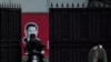 在上海，习近平画像前带口罩的人（2020年2月10日）