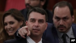 La policía federal de Brasil registró hace unos días la casa de Flavio Bosonaro, que en esta imagen de octubre de 2018, durante certificación de resultados a favor de su padre, aparece junto a su hermano mayor Carlos. Las investigaciones se han ampliado a todo el clan familiar.