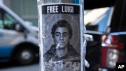 Plakat sa likom Luđija Manđonea, optuženog za ubistvo direktora zdravstvenog osiguranja, i porukom "Oslobodite Luiđija" u Njujorku (AP Photo/Julia Demaree Nikhinson)