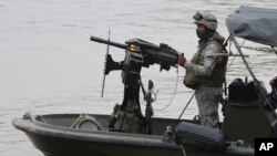 Soldados de la Armada colombiana patrullan el río Arauca, la frontera natural con Venezuela, visto desde Arauquita, Colombia, el viernes 26 de marzo de 2021.