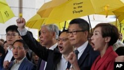 "Occupy Central" leaders, from right, Tanya Chan, Chan Kin Man, Benny Tai, Chu Yiu Ming and Lee Wing Tat shout slogans before entering a court in Hong Kong, Nov. 19, 2018.