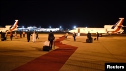Les travailleurs de l'aéroport déploient le tapis rouge à Abuja, Nigeria May 14, 2016. 