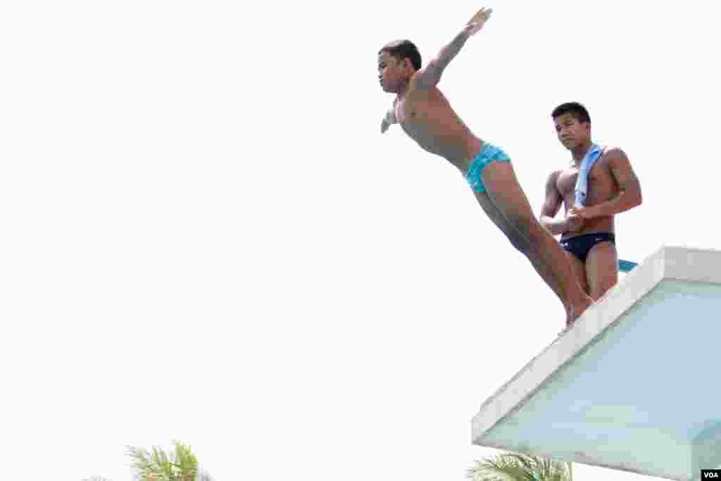 Jordan Pisey Windle, a Cambodian-born U.S. diving champion, watches on as a young Cambodian prepares to dive into the pool, in Phnom Penh, Cambodia, May 12 2016. (Hean Socheata/ VOA Khmer)