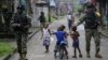 Niños juegan mientras fuerzas especiales de la Armada patrullan en Buenaventura, la principal ciudad puerto en la costa del Pacífico en Colombia.