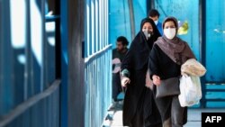 FILE - Women wearing protective masks amid the coronavirus pandemic walk in Iran's capital, Tehran, April 5, 2021.