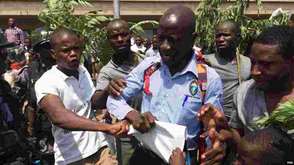 Kizza Besigye a entouré de quelques-uns de ses partisans avant d’être arrêté par la police lors d’une manifestation à Kampala, Ouganda, février 2016.