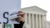 FILE - An abortion- rights activist holds a box of mifepristone pills as demonstrators from both anti-abortion and abortion-rights groups rally outside the Supreme Court in Washington, March 26, 2024. 