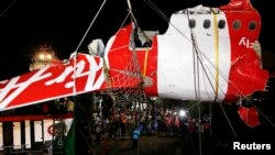 Bagian ekor pesawat AirAsia QZ8501 diangkat dari kapal ke truk di Pelabuhan Kumai, dekat Pangkalan Bun, Kalimantan Tengah (11/1). (Reuters/Darren Whiteside)