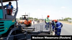 Des ouvriers effectuent des travaux sur une route près de la capitale zambienne, Lusaka, le 15 novembre 2013.