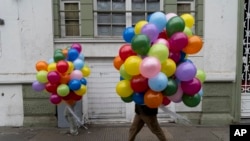 Varias personas llevan globos a una marcha en el Día Internacional de los Trabajadores en Santiago, Chile, el miércoles 1 de mayo de 2024. (Foto AP/Matías Basualdo)