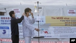 A patient dons a mask to protect against MERS, Middle East Respiratory Syndrome, at Seoul National University Hospital in South Korea, June 1, 2015. 