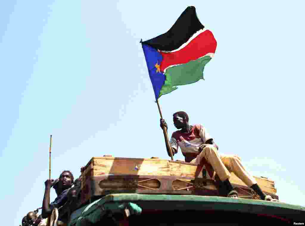 A man waves a South Sudanese flag as he celebrates referendum results in the town of Abyei, Oct. 31, 2013.