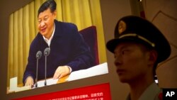 시진핑 중국 국가주석의 모습이 게시된 베이징 시내 행사장에서 공안이 경비하고 있다. (자료사진)