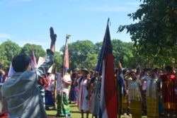 FILE - This handout photo from the KNU Dooplaya District taken April 28, 2021, shows protesters in Karen ethnic costumes making the three-finger salute during a demonstration against the military coup in Myanmar's eastern Karen state.