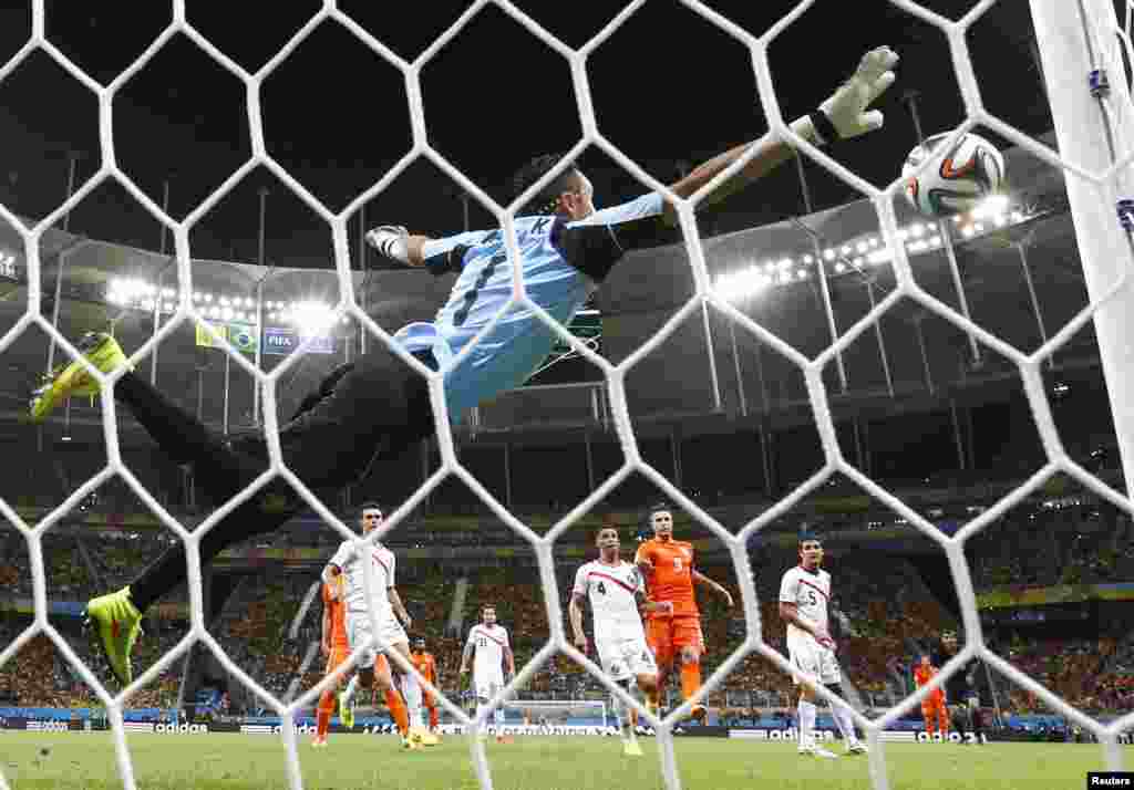 Kosta Rika darvozaboni Keylor Navas Niderlandiya hujumchisi Vesli Sneyder tepgan jarima to'pini qaytarmoqda, 5-iyul, 2014-yil.
