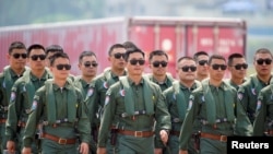 Miembros del equipo acrobático del Halcón Rojo de la Fuerza Aérea del Ejército Popular de Liberación de China (EPL) asisten a la Exposición Internacional de Aviación y Aeroespacial de China en la provincia de Guangdong, China, el 28 de septiembre de 2021.