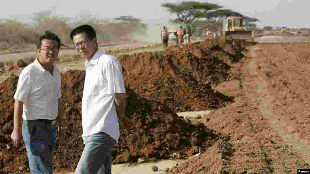 Wu Yi Bao (d), gestionnaire de projet de construction de route de la société Chine Wuyi, discute avec un collègue sur le site de travaux près de la ville d'Isiolo, à environ 320 km au nord de Nairobi, Kenya, 7 juillet 2008.