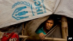 Un Rohingya regarde par la tente du camp de réfugiés de Balukhali à 50 kilomètres de Cox's Bazar, au Bangladesh, le 14 janvier 2018. 