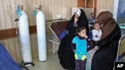 In this Friday, March 11, 2016 photo, people exposed to a chemical attack wait for treatment at a hospital in Taza, 10 miles (20 kilometers) south of Kirkuk in northern Iraq.