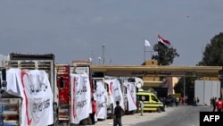 ARCHIVO - Camiones de la Media Luna Roja Egipcia cargados con ayuda hacen fila frente al cruce fronterizo de Rafah con la Franja de Gaza palestina, el 23 de marzo de 2024, en medio de batallas en curso entre Israel y el grupo militante Hamas.