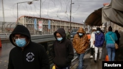 Migrantes deportados de Estados Unidos caminan hacia México por el puente fronterizo internacional Paso del Norte, en esta foto tomada desde Ciudad Juárez, México el 29 de enero de 2021. REUTERS / Jose Luis Gonzalez