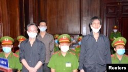 Jurnalis lepas dari Asosiasi Jurnalis Independen Vietnam, Phạm Chí Dũng (kanan),Lê Hữu Minh Tuấn (tengah) dan Nguyen Tuong Thuy (kiri) di pengadilan di Ho Chí Minh City, Vietnam, Selasa, 5 Januari 2021. (Foto: VNA via Reuters)