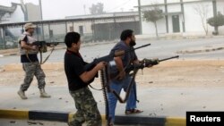 Para anggota milisi Libya menembaki sebuah bangunan (foto: dok). Kawanan bersenjata menewaskan seorang warga AS di Benghazi Kamis, 5/12. 