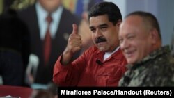 FILE - Venezuela's President Nicolas Maduro gestures during a TV show with National Constituent Assembly member Diosdado Cabello in Caracas, Venezuela, April 11, 2018. 