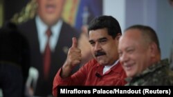 FILE - Venezuela's President Nicolas Maduro gestures during a TV show with National Constituent Assembly member Diosdado Cabello in Caracas, Venezuela, April 11, 2018. 
