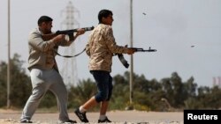 Des combattants de Misrata tirent des armes sur des militants du groupe Etat islamique près de Syrte le 15 mars 2015