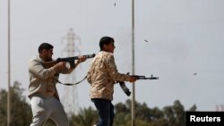 Des combattants tirent à la mitraillette en pleine rue à Misrata, près de Sirte, en Libye le 15 mars 2015.