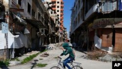 Un enfant syrien à bicyclette, le 26 février 2016 à Homs. (AP Photo/Hassan Ammar)