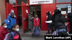 Students arrive at P.S. 134 Henrietta Szold Elementary School, Monday, Dec. 7, 2020, in New York. Public schools reopened for in-school learning Monday after being closed since mid-November. (AP Photo/Mark Lennihan)