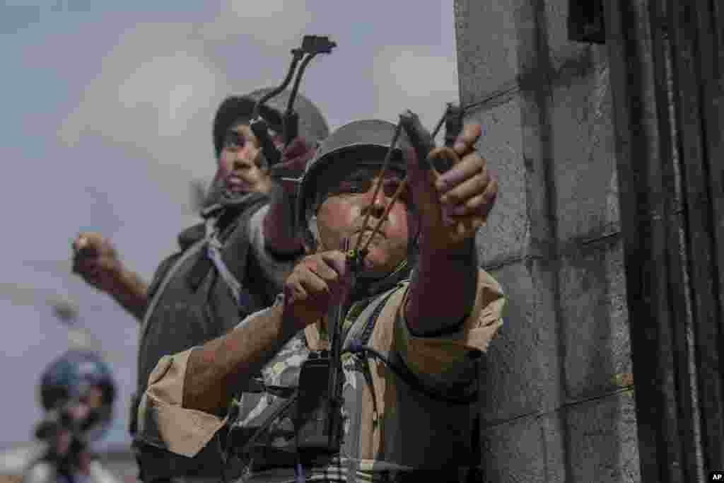 Indian paramilitary soldiers use slings to shoot glass marbles at Kashmiri protesters in Srinagar, Indian controlled Kashmir.