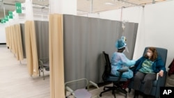 Un paciente de COVID-19 recibe una infusión en un centro ambulatorio de tratamientos terapéuticos en un hospital de campaña en Cranston, Rhode Island, el 14 de diciembre de 2020.