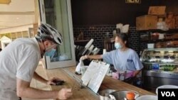 Un cliente hace una parada en la Compañía Pan y Agua para recoger unos pasteles.