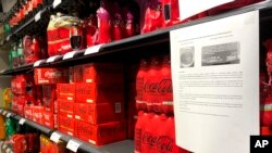 Una nota de advertencia puede verse junto a cajas de refrescos en un estante de un supermercado en Amberes, Bélgica, después de que Coca-Cola retirara del mercado algunos de sus refrescos en Europa, el 28 de enero de 2025.