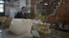 FILE - An Afghan journalist walks by an exhibit of minerals on the way to a news conference by the Afghan Minister of Mines in Kabul, Afghanistan, June 17, 2010