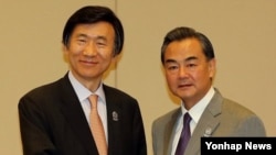 지난 8월 윤병세 한국 외교부 장관(왼쪽)이 미얀마 네피도 국제 컨벤션 센터에서 열린 한·중 외무장관 회담에서 왕이 중국 외교부장과 악수하고 있다. (자료사진)