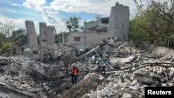 Volunteers search for bodies of people killed during Russia's attack in the town of Izium