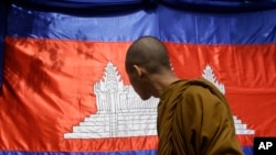 រូបឯកសារ៖ ព្រះសង្ឃមួយអង្គសម្លឹងមើលទង់ជាតិខ្មែរ ដែលត្រូវបានដាក់តាំងនៅមុនពិធីបុណ្យចូលឆ្នាំប្រពៃណីខ្មែរ នៅរាជធានីភ្នំពេញ កាលពីថ្ងៃទី ៤ ខែមេសា ឆ្នាំ ២០១៧។