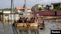 Les gens utilisent un bateau de fortune pour se déplacer après que le fleuve Congo ait atteint son niveau le plus élevé, provoquant des inondations à Kinshasa, en République démocratique du Congo, le 10 janvier 2024.