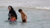 FILE - A Muslim woman wears a burkini, a swimsuit that leaves only the face, hands and feet exposed, on a beach in Marseille, France, Aug. 17, 2016.