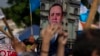 Los manifestantes sostienen una pancarta con el retrato del presidente guatemalteco Alejandro Giammattei durante una protesta por la reelección de Consuelo Porras como fiscal general, Ciudad de Guatemala, el sábado 21 de mayo de 2022.