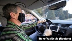 Montenegro, Podgorica, A taxi driver wears a protective mask and gloves after government ban all public transport due first two registred cases of coronavirus