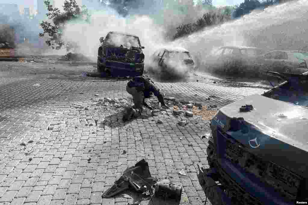 An Israeli police officer investigates at the scene where a rocket fired from Lebanon landed in Israel, amid cross-border hostilities between Hezbollah and Israel, near the border with Lebanon in northern Israel.